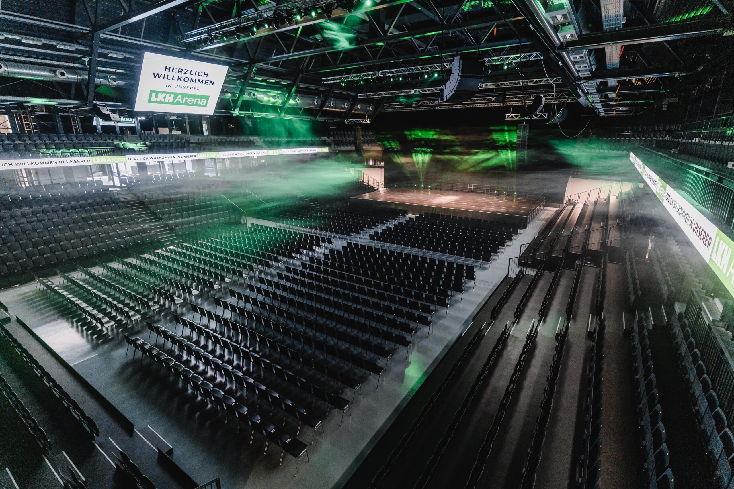 lkh arena in grünem licht und stuhlreihen protones sound & light veranstaltungstechnik