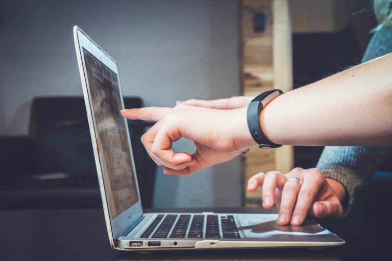 zwei personen zeigen auf laptop beratung protones veranstaltungstechnik kaufen