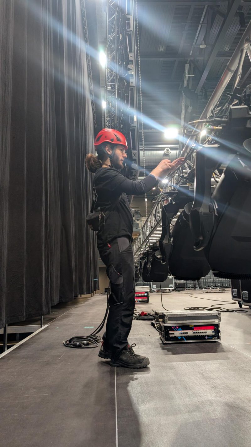 Aushilfe Veranstaltungstechnik in Lüneburg beim Aufbau von Bühnenbeleuchtung mit Helm und Scheinwerfern